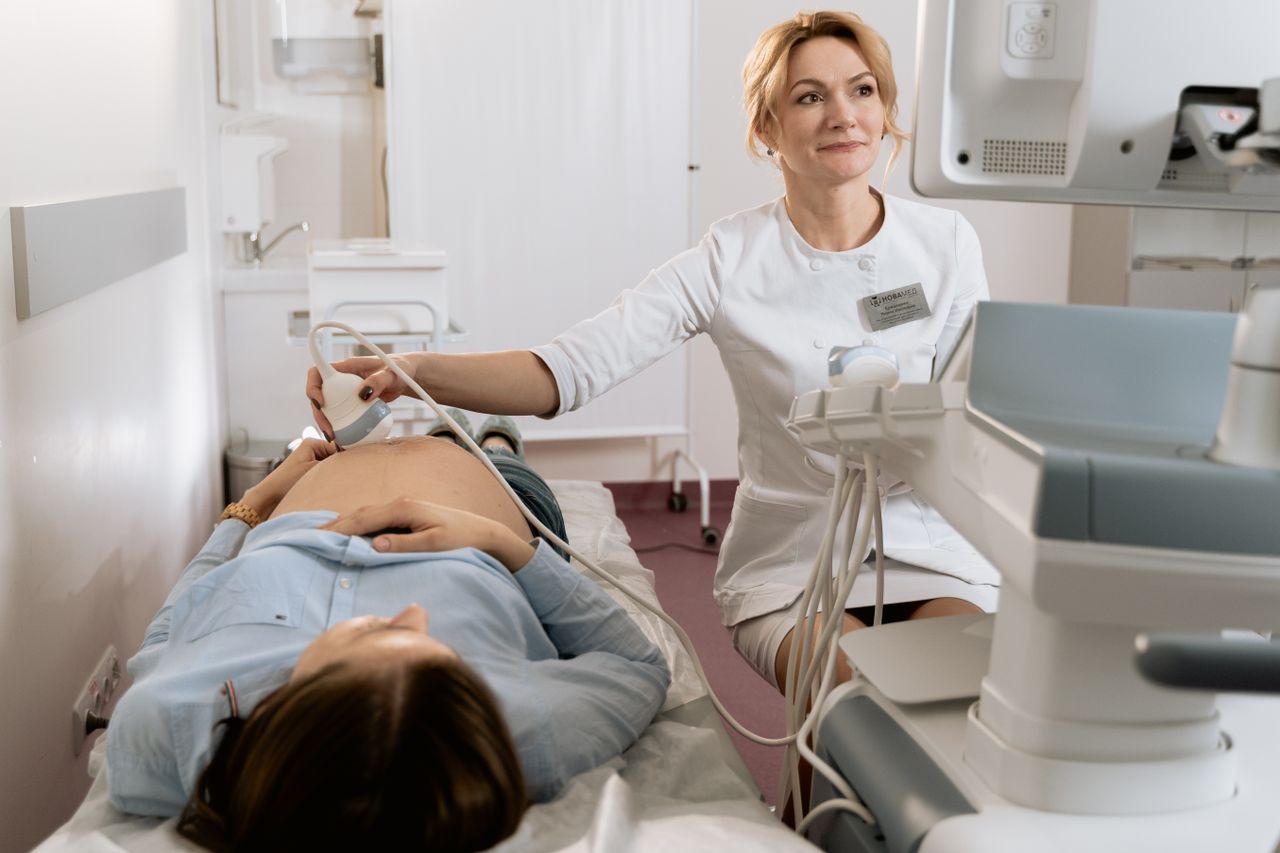 Mastering the First Impression: Your intriguing post title goes here A pregnant woman receiving an ultrasound exam conducted by a healthcare professional in a medical clinic.